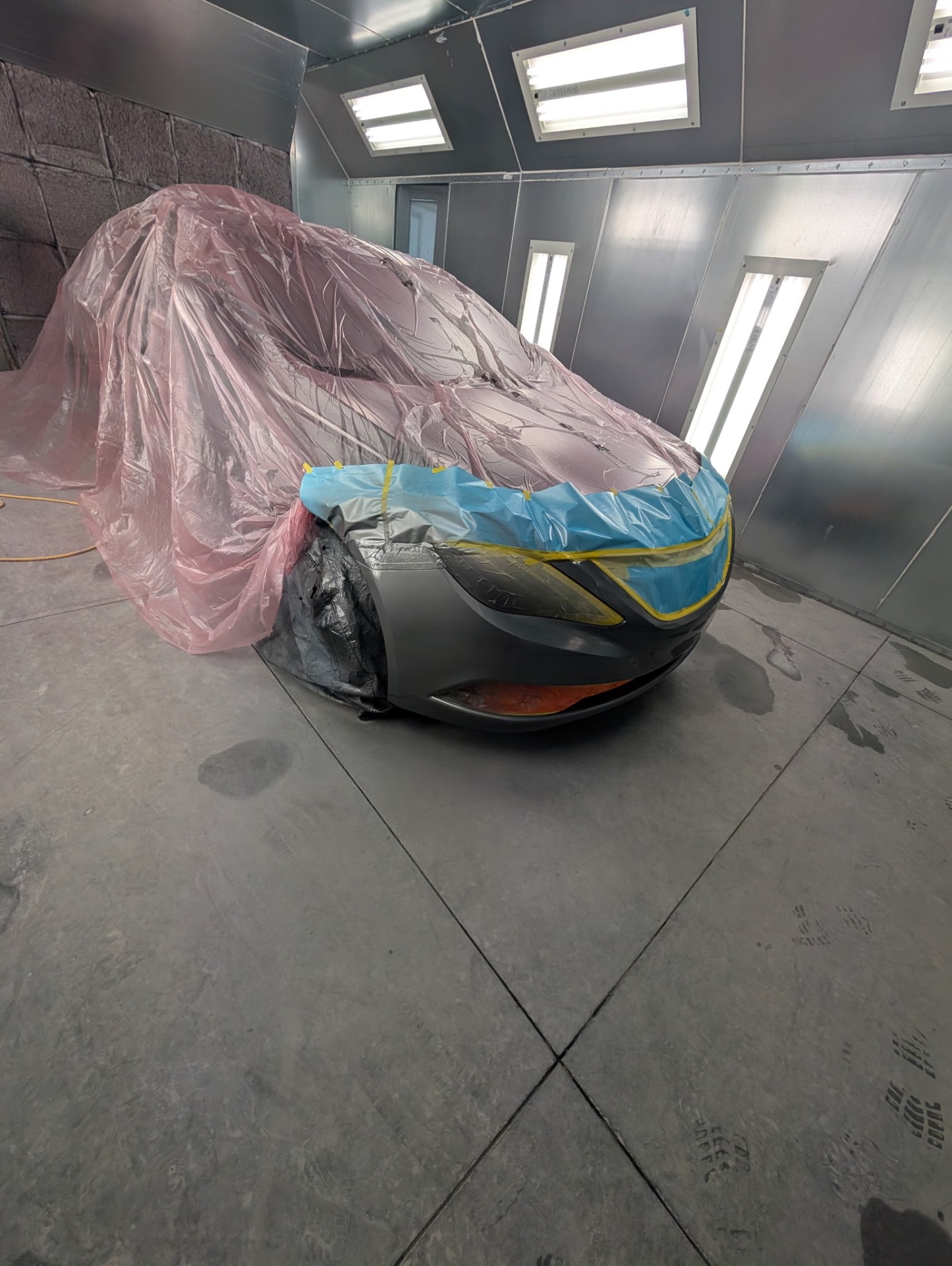 Vehicle masked and prepped for painting in the spray booth